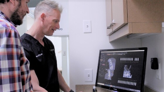 Dentist and patient looking at digital x-rays