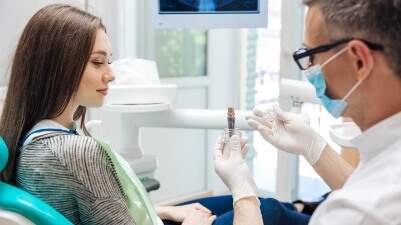 Dentist describing the stages of dental implant tooth replacement