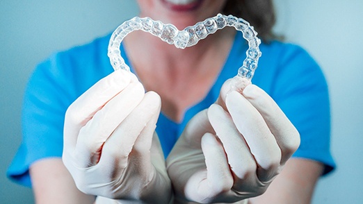 dentist holding two clear aligners