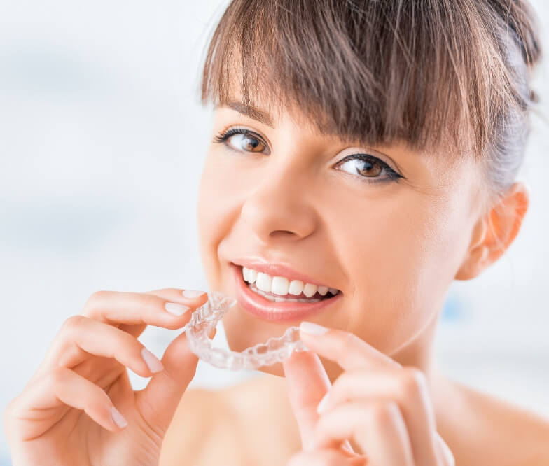 Woman placing an Invisalign clear aligner