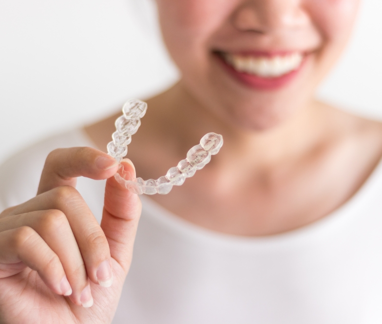 Person holding an orthodontic aligner