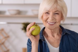 older woman holding an apple