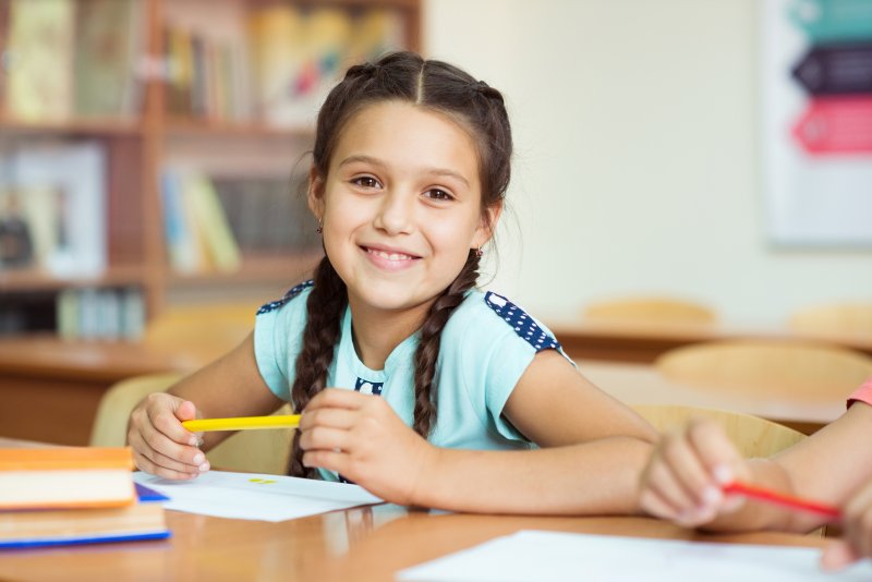 young girl smiling while in school