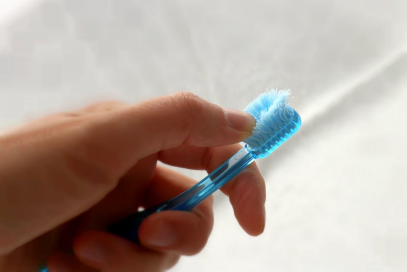 closeup of person touching old toothbrush