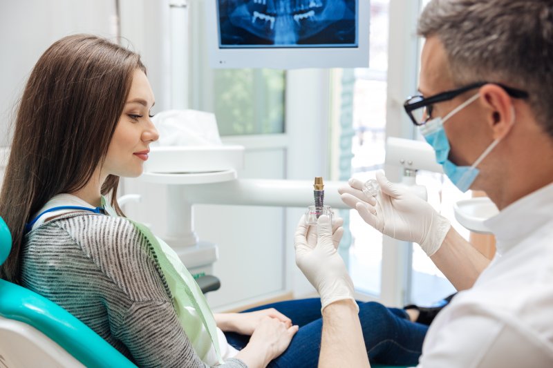 dentist in Houston explaining dental implants 