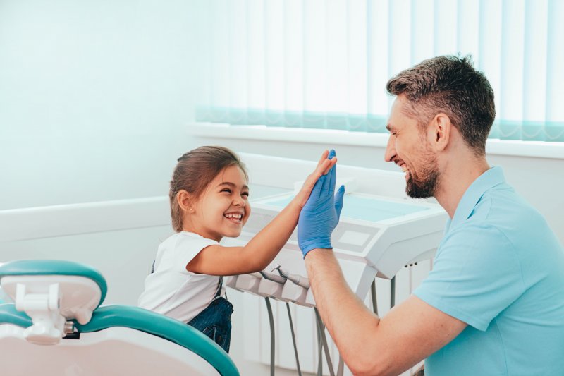 young girl high-fiving dentist 