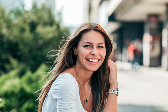 woman smiling while standing outside